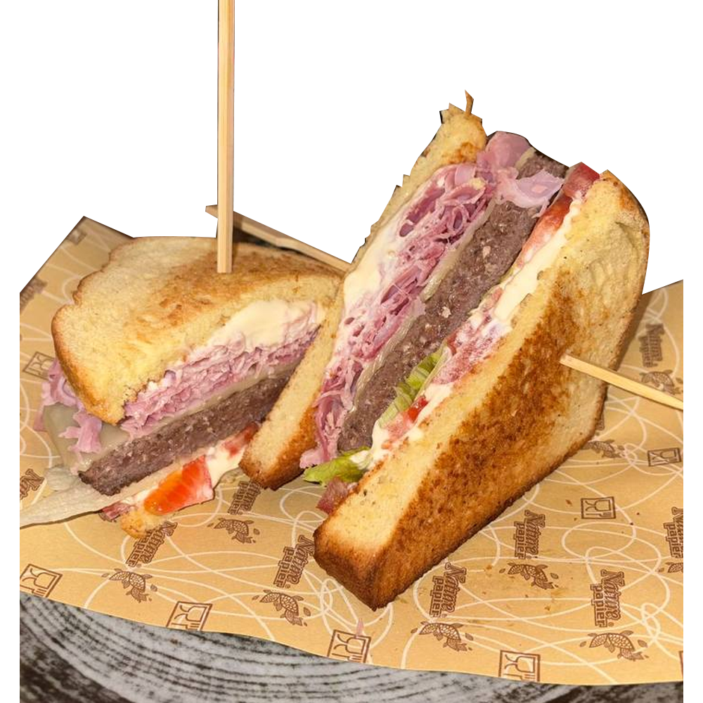 Two toasted sandwich halves filled with layered meat, vegetables, and sauce, held together with wooden skewers on a paper lining.